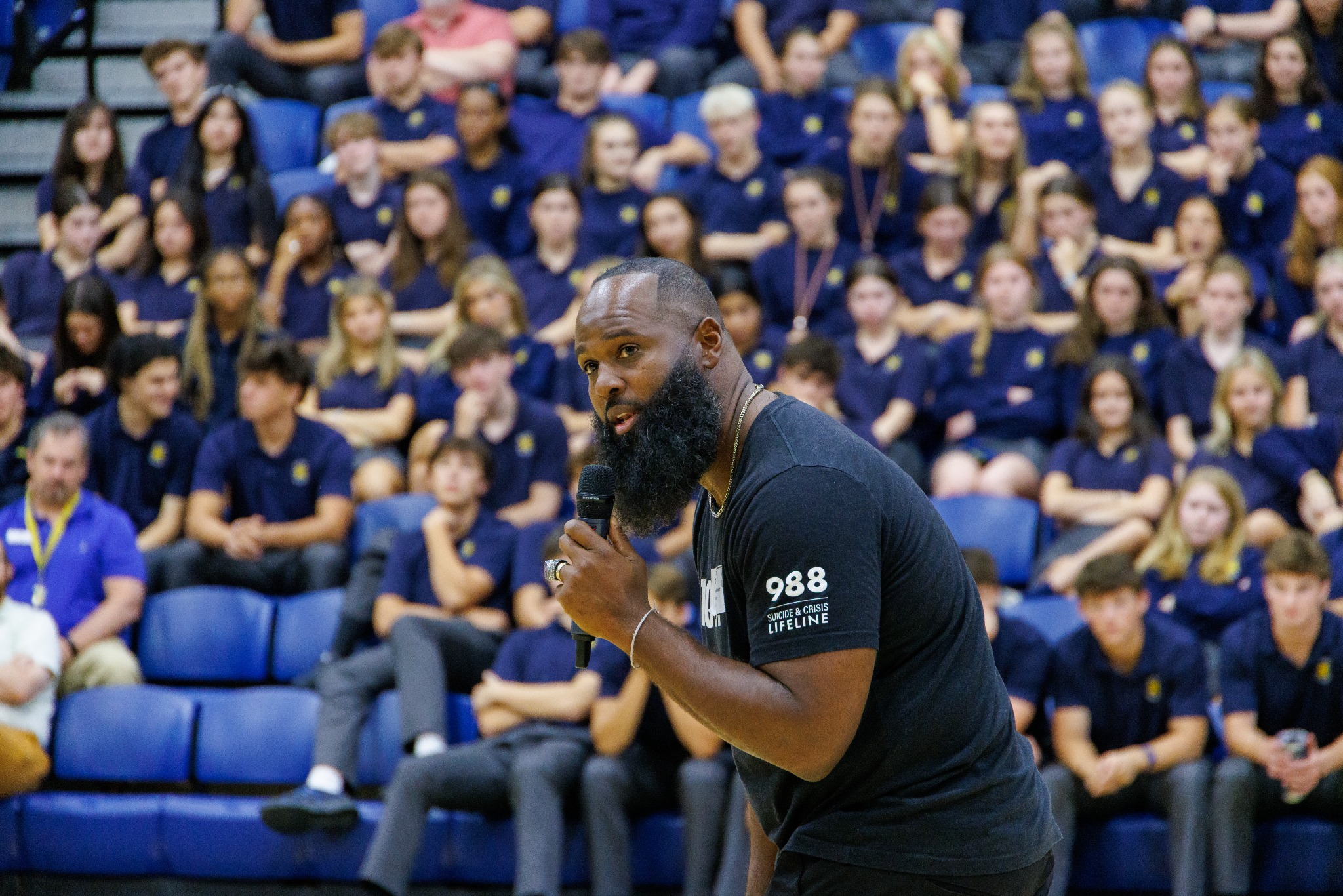 Andre Fluellen speaking directly with students in the bleachers