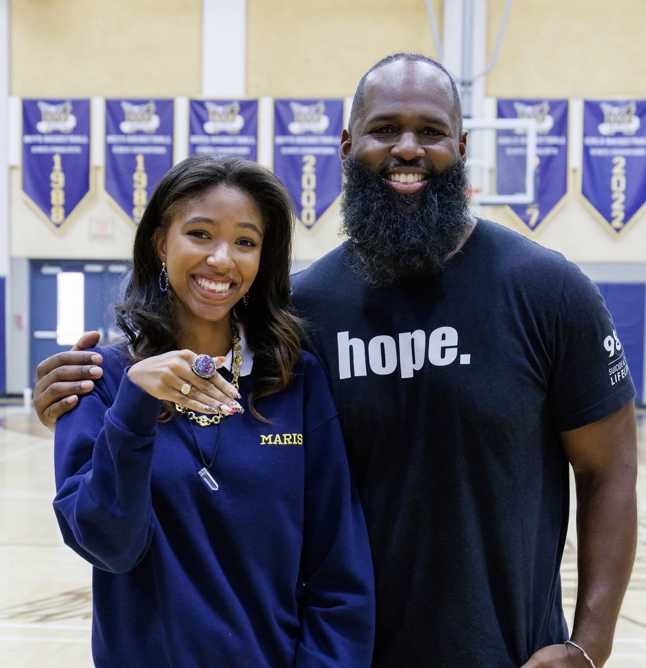 Andre Fluellen with a student in a school gym