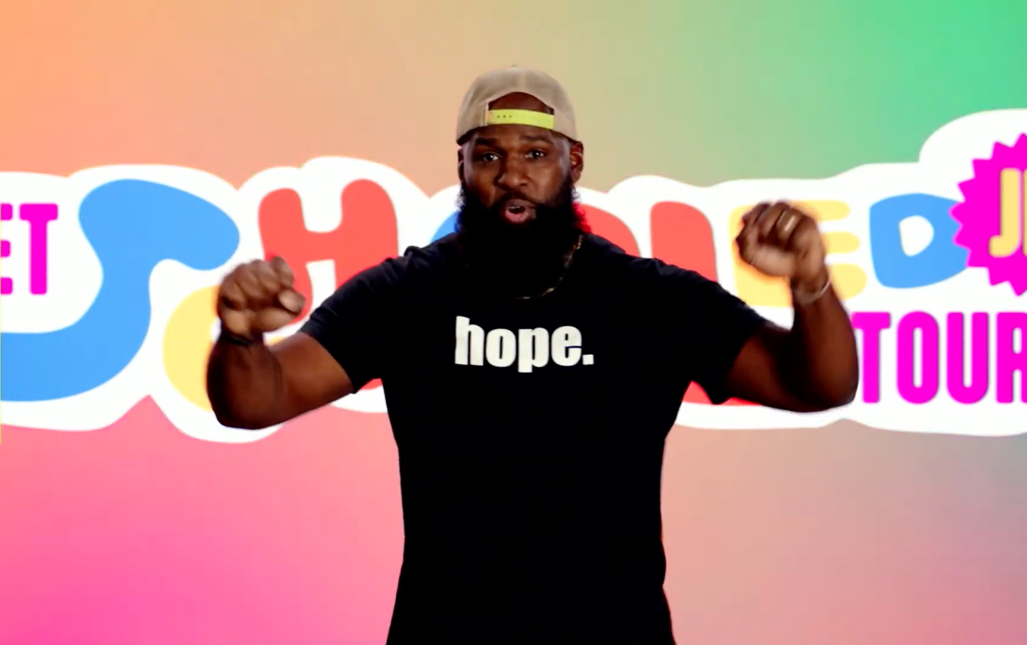 Andre Fluellen presenting his live virtual elementary assembly against a colorful backdrop